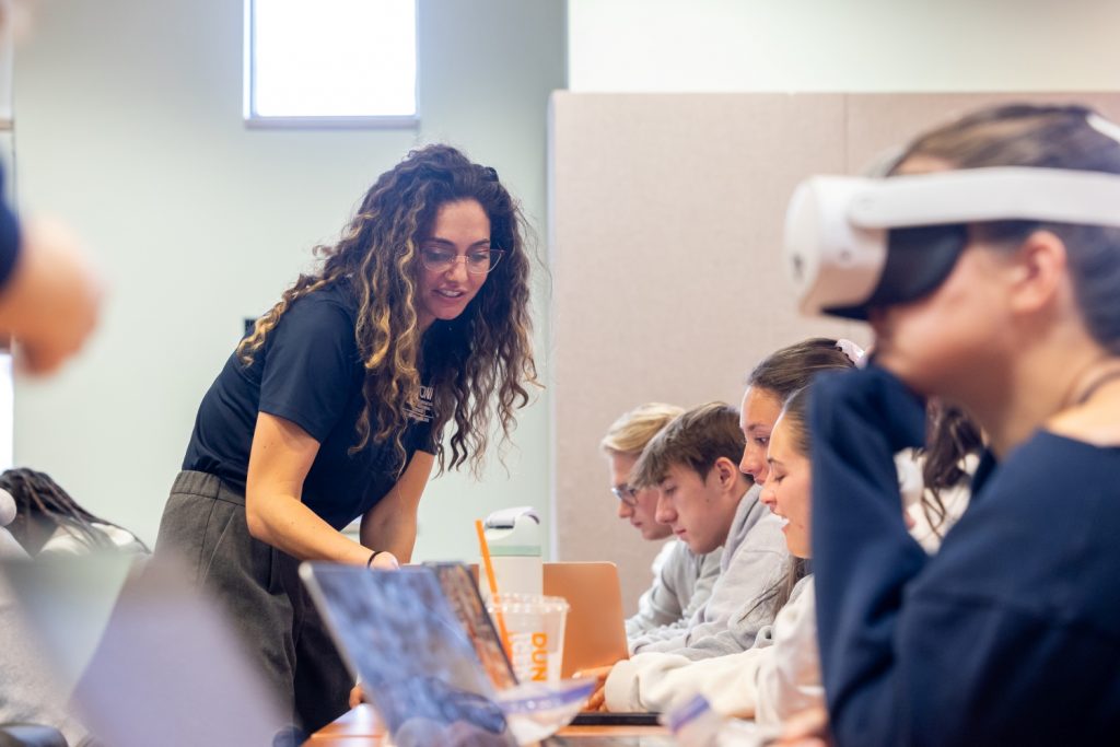 Professor Paula McDowell helps students in her U.S. Healthcare System and Professional Practice class look through models in Wilson Hall on Thursday, Oct. 30, 2025. (Sydney Herdle/UConn Photo)